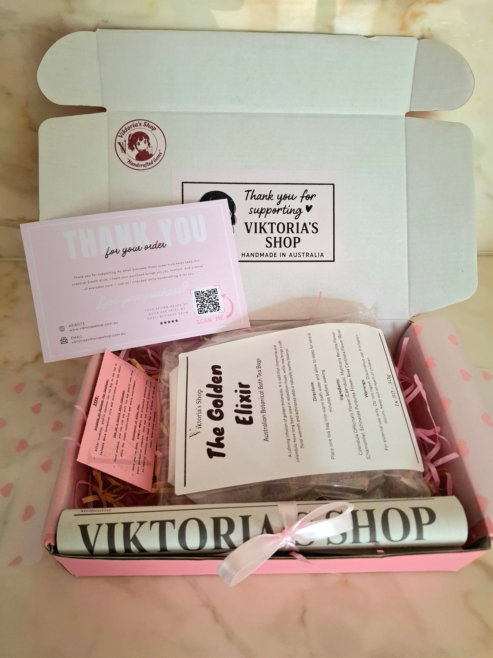 Viktoria's Shop packaging — pink gift box with branded scroll, thank you card and product